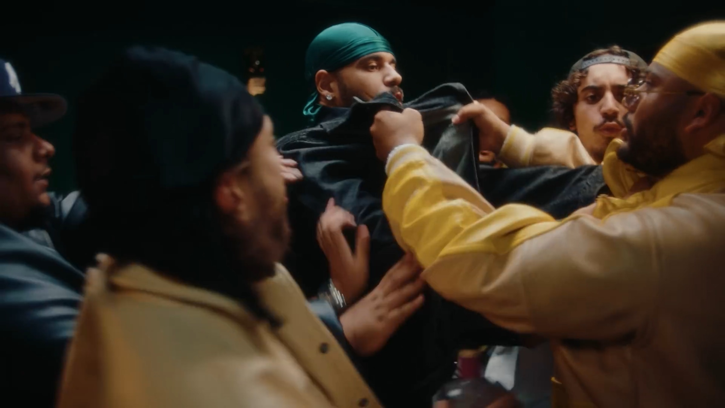 Bousculade : plusieurs hommes en vestes de sport se tiennent par le col dans le salon vert.